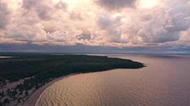 Sakin dalgalar kumlu kıyılarda süzülür. Titreyen gökyüzü gün batımında bulutlarla dans eder. Doğada sakin bir atmosfer yaratır..