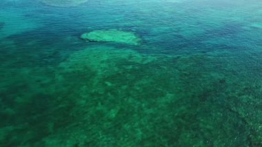 Kristal berrak sular büyüleyici bir sualtı dünyası sergiliyor. Güneş ışığı mercan oluşumları üzerinde dans ediyor, yüzeyin altında keşif ve macera yaratıyor..