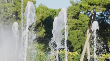 Bereketli bir bahçede, birkaç çeşmeden neşeyle fışkıran su güneşli bir öğleden sonra ferahlatıcı bir atmosfer yaratır..