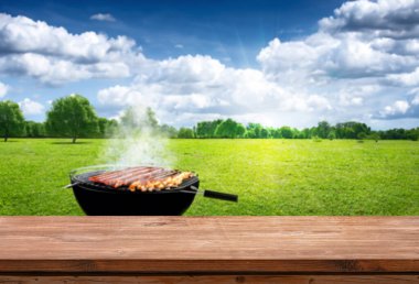 Yazın açık havada barbekü, ahşap masa, bulanık arka plan.