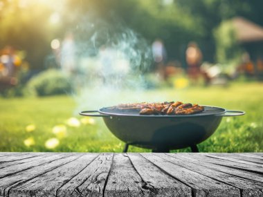 Bahçe bahçesinde yaz zamanı ızgara barbekü, ahşap masa, bulanık arka plan