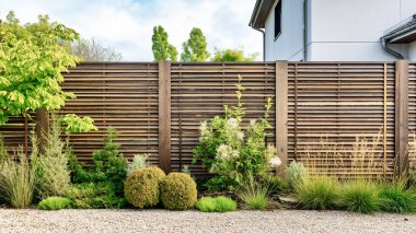 Bahçe bahçesinde yeşil çimenler, bitkiler ve ahşap çitler