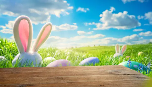 兔子的耳朵和蛋在草地上 木制桌子 模糊的复活节背景 图库图片