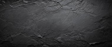 Kumlu taş desenli pürüzlü siyah duvar.