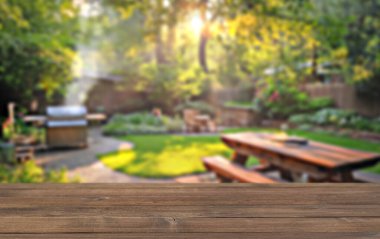 Bahçe bahçesinde yaz partisi, barbekü, ahşap masa, bulanık arka plan.