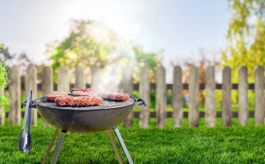 Bahçe bahçesinde yaz zamanı ızgara barbekü, ahşap masa, bulanık arka plan