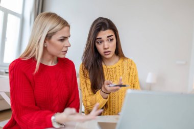 Akıllı kız öğrenciler ödev projesi hakkında tartışıyorlar dizüstü bilgisayardan bilgi okuyorlar, özel ders izleyen genç kadınlar ofiste sohbet ediyorlar.