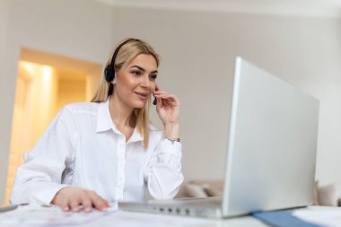 Kulaklık takan genç, dost canlısı bir bayan ajan. Güzel bir iş kadını mikrofon takıyor ofiste tele pazarlamacı olarak çalışıyor çağrı merkezi iş konsepti..