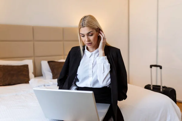 stock image Young business woman at hotel room working on a laptop on the bed and smiling lifestyle concepts, Business trip