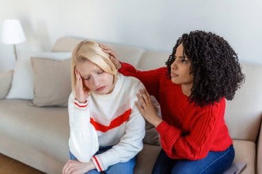 Arkadaşını sakinleştirmeye çalışan bir arkadaş. Kadın ağlıyor. Genç bayan sorununu arkadaşıyla paylaşıyor. Depresyonda bir kadın. Evdeki oturma odasında oturan üzgün arkadaşını teselli eden bir kadın.