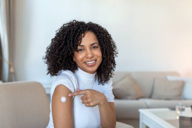 Covid-19 Aşılama. Coronavirus antiviral aşı aşısından sonra kolunu gösteren mutlu Afrikalı kadın portresi. Kapsamlı Dokunulmazlık Kampanyası Kavramı.