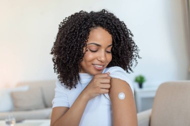 Covid-19 Aşılama. Coronavirus antiviral aşı aşısından sonra kolunu gösteren mutlu Afrikalı kadın portresi. Kapsamlı Dokunulmazlık Kampanyası Kavramı.