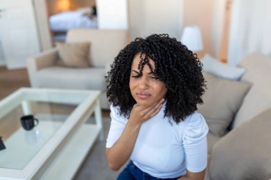 Close up of young woman rubbing her inflamed tonsils, tonsilitis problem, cropped. Woman with thyroid gland problem, touching her neck, girl has a sore throat