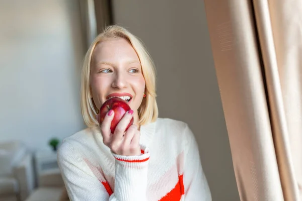 Wanita Cantik Muda Makan Apel Segar Dan Melihat Melalui Jendela — Stok Foto