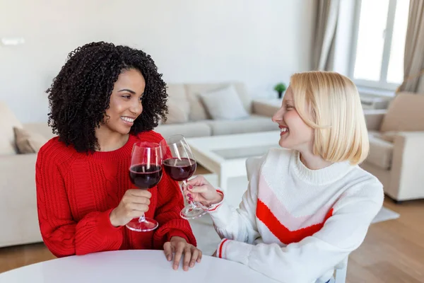 stock image Two female friends spending time together at home, sitting on sofa. copy space. Cheerful women drinking wine