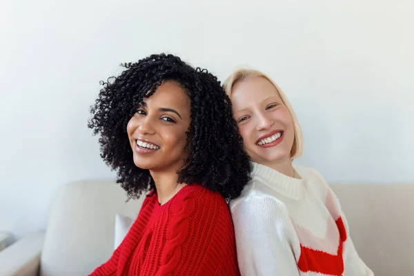 Zwei Schöne Frauen Blond Und Afrikanisch Strickpullovern Auf Dem Sofa — Stockfoto