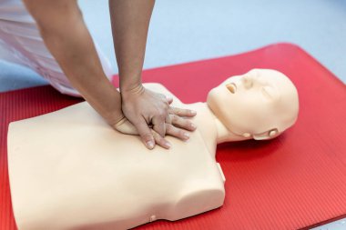 Kalp masajı eğitimi tıbbi prosedürü. Sınıftaki kalp masajı bebeğine göğüs kompresyonu uygulanıyor. İlk yardım eğitimi, kardiyopulmoner resüsitasyon. Suni teneffüste ilk yardım kursu..