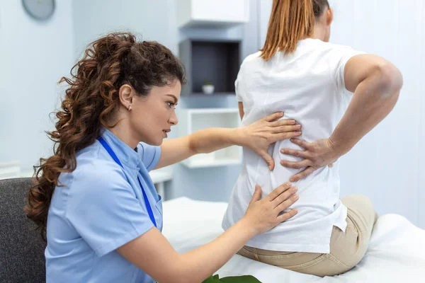 Physiotherapist doing healing treatment on womans back. Back pain patient, treatment, medical doctor, massage therapist.office syndrome