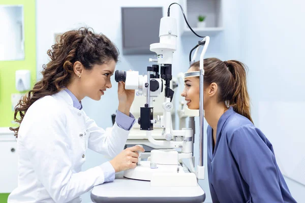現代のクリニックでの検査中に女性患者と目の医者 眼科医は眼の健康のための特別な医療機器を使用しています — ストック写真