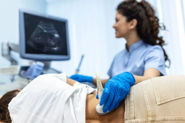 Doctor conducts ultrasound examination of patientv kidneys. Internal organs ultrasound concept. female\'s lower back diagnosis carried out with the use of an ultrasound
