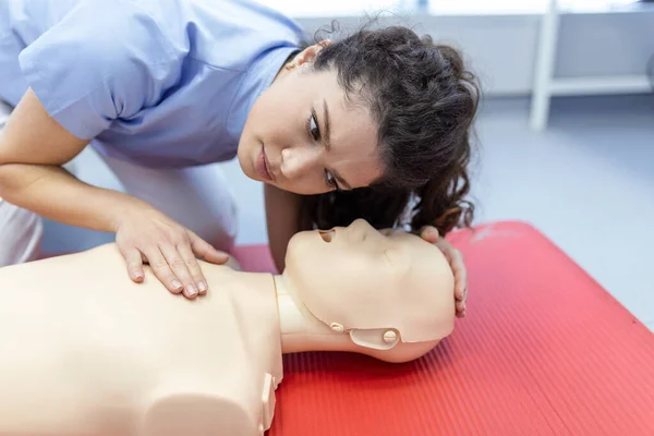 stock image woman practicing cpr technique on dummy during first aid training. First Aid Training - Cardiopulmonary resuscitation. First aid course on cpr dummy.