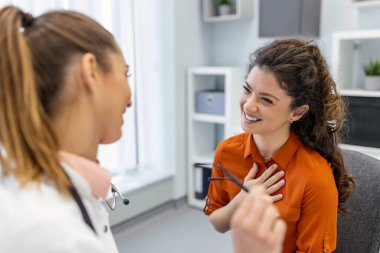 Genç bayan profesyonel doktor hastaya danışmanlık yapıyor. Tıbbi muayenede yetişkin kadın müşteriyle konuşuyor. Hastalık tedavisi. Tıbbi sağlık konsepti