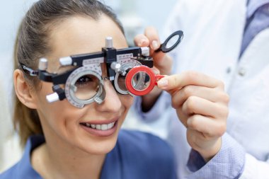 Optometrist deneme çerçevesi ile kadın muayene Oftalmolog. kadın hasta Oftalmolojik klinikte vizyonu kontrol etmek.