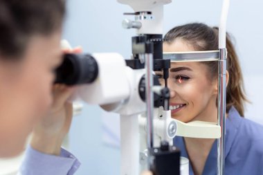 Kadın doktor Oftalmolog modern klinikte çekici genç kadının göz vizyonu kontrol ediyor. Doktor ve hasta Oftalmoloji Kliniği