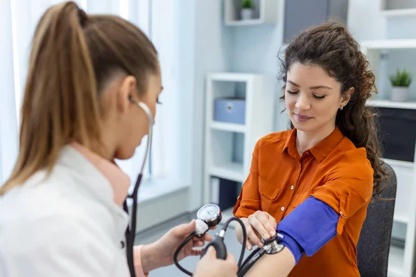 测量血压 年轻妇女在现代诊所看女医生 测量血压 压力表 高血压和高心率 — 图库照片