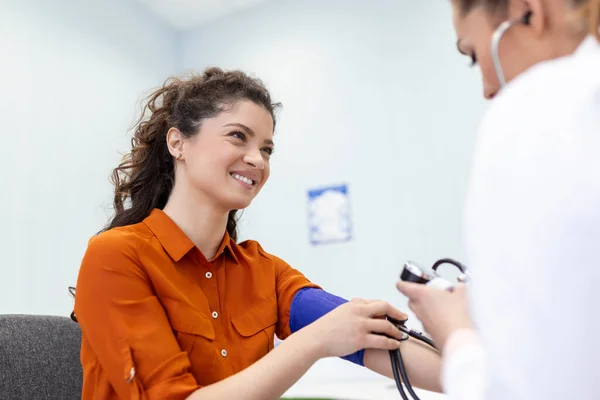診療所で診察中の女性患者の血圧を測定する看護師 患者の動脈血圧をチェックする医師 — ストック写真