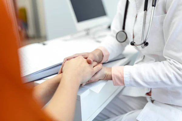 stock image Young female doctor hold hand of caucasian woman patient give comfort, express health care sympathy, medical help trust support encourage reassure infertile patient at medical visit, closeup view.