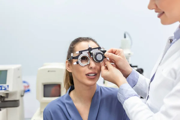 研究室では 眼科機器の目健康チェックを追加 若いきれいな女の子のビジョンを改善しようと特別なデバイス Oculist を使用しています 目の健康のための医療機器の操作 — ストック写真