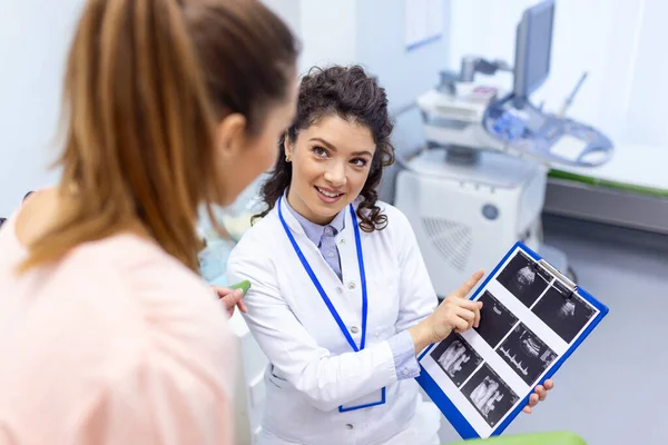 婦人科医は オフィスでの医療相談中の女性の健康の特徴を説明し 若い女性患者に超音波で画像を示しています — ストック写真