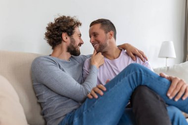 Carefree Gay Çiftin Ev İçinde Portresi. Mutlu eşcinsel çift el ele tutuşarak vakit geçiriyor.