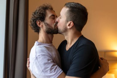 Birbirine aşık iki genç lgbtq eşcinsel çifti. Birbirlerine sarılıyorlar. Şehvetli, duygusal bir anın tadını çıkarıyorlar.