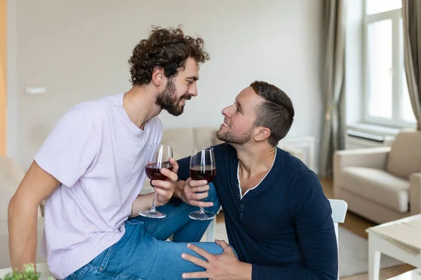 Lgbtq 껴안고 집안에서 와인을 먹는다 로맨틱 거실에 서로를바라보고 있습니다 가집에서 — 스톡 사진
