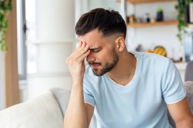 Stresli hissediyorum. Sinirli yakışıklı genç adam başını dokunmadan ve evde kanepede otururken gözleri kapalı tutmak
