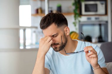 Tired man taking off glasses rubbing dry irritated eyes to relieve pain feeling discomfort suffers eyestrain poor blurry vision, organ of sight fatigue concept clipart