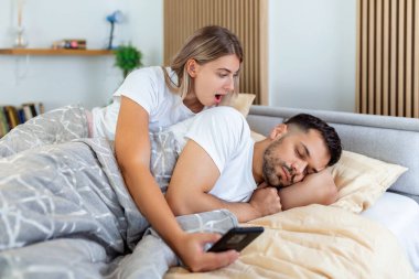 Kadın kıskanç ve şüpheci ve o yatak odasında yatarken ortağının akıllı telefonunda casusluk yapıyor. Kadın, o uyurken kocasının telefonunu gözetliyormuş. Güvensizlik, kıskançlık kavramı.