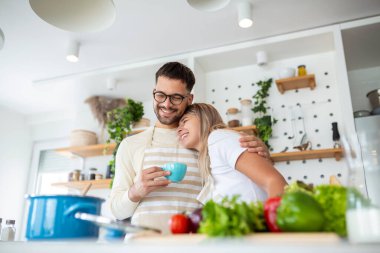 Aşık çiftler mutfakta birlikte vakit geçirirler. Mutfakta kahve içen ve sabah birlikte vakit geçiren sevimli genç bir çift.