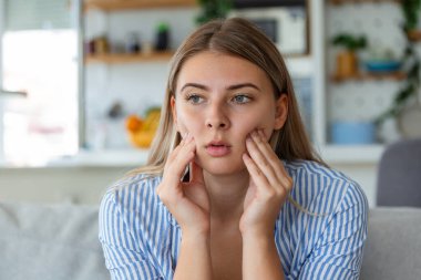 Diş ağrısı ve diş hekimliği. Çok güzel genç bir kadın, dişleri çok güçlü, yanakları elleyerek acı çekiyor. Dişi Acılı Diş Ağrısı. Diş bakımı ve sağlık konsepti. Yüksek Çözünürlük