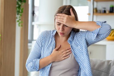 Breathing, respiratory problem, asthma attack, pressure, chest pain, sun stroke, dizziness concept. portrait of woman received heatstroke in hot summer weather, touching her forehead clipart