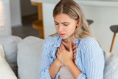 Young woman having chestpain,Acute pain, possible heart attack.Effect of stress and unhealthy lifestyle concept.