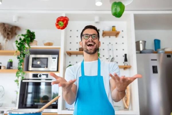 Fröhlicher Junger Mann Wirft Gemüse Die Küche — Stockfoto