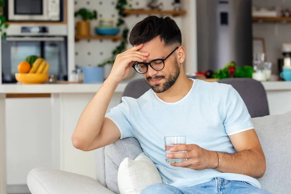 Young Man Suffering Strong Headache Migraine Sitting Glass Water Sofa — Stock Photo, Image