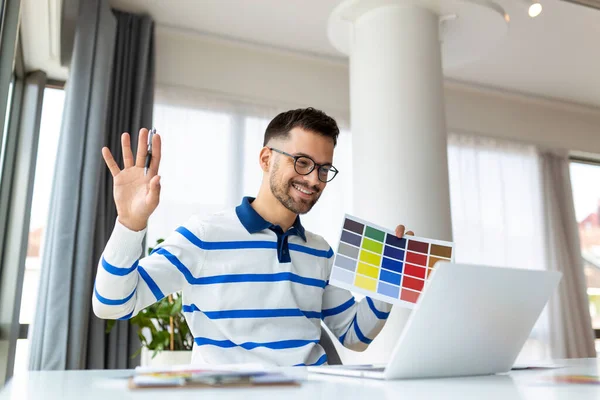 Graphic Design Courses Online. Young Man Holding Colour Swatch And Using Laptop Computer At Home, Study In Internet, Male Freelance Designer Planning Gamma For Future Interior, Free Space