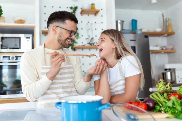 Hermosa Pareja Joven Mira Alimentan Mutuamente Con Sonrisas Mientras Cocinan — Foto de Stock