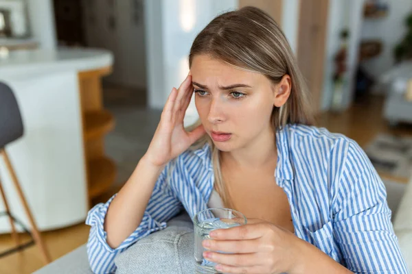 Deprimida Jovem Mulher Com Dor Cabeça Enquanto Bebe Água Sofá — Fotografia de Stock