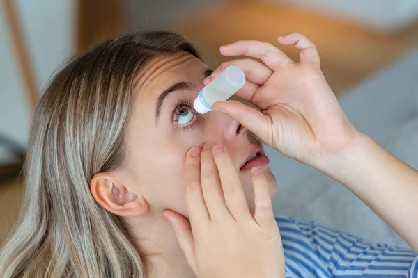 Woman using eye drop, woman dropping eye lubricant to treat dry eye or allergy, sick woman treating eyeball irritation or inflammation woman suffering from irritated eye, optical symptoms