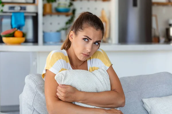 忧心忡忡的女人坐在家里的沙发上 沮丧困惑的女性感到不快乐 个人生活中的问题 与男朋友的争吵和意外怀孕观念 — 图库照片